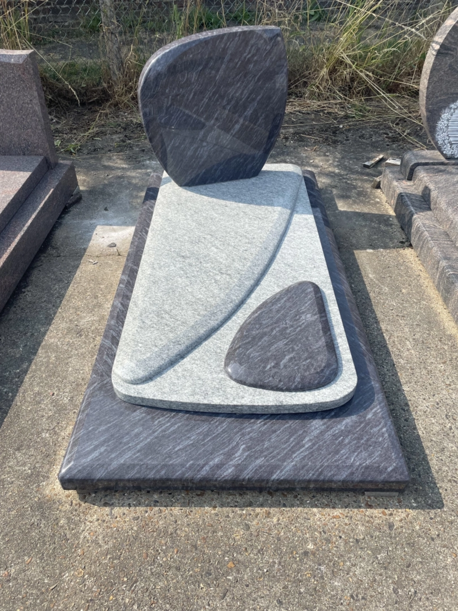 Monument funéraire moderne bicolore en granit gris et noir.