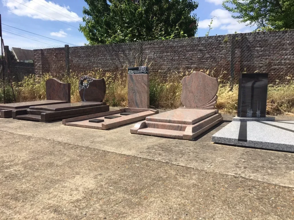 Exposition de monuments funéraires en granit de différentes couleurs.