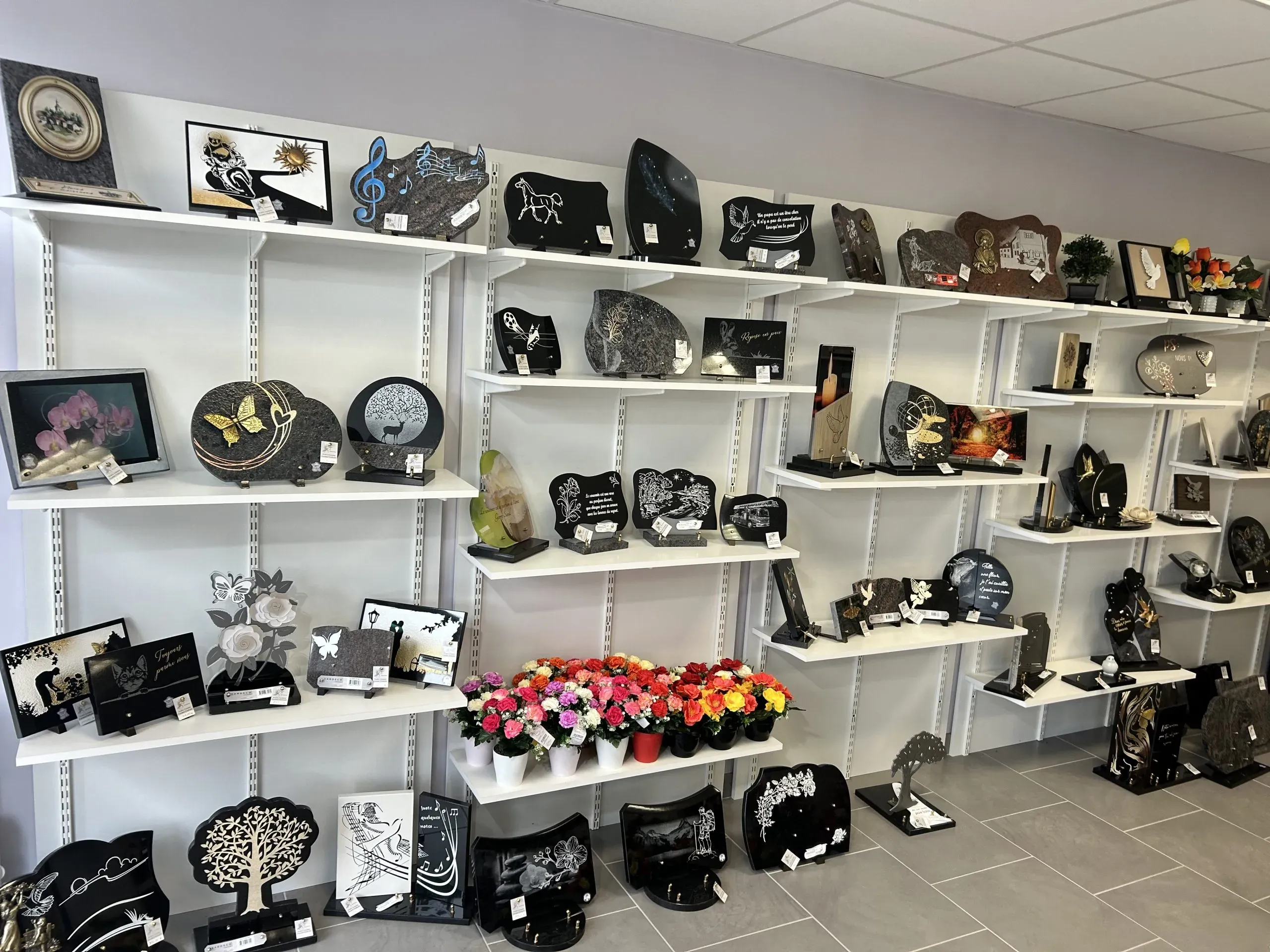Exposition de plaques funéraires personnalisées et articles commémoratifs en magasin.